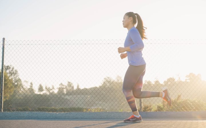 woman jogging near wire fence