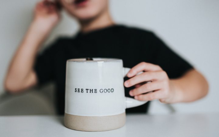 woman in black shirt holding white ceramic mug